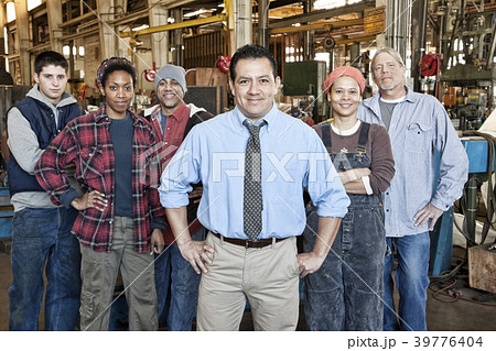 Mixed race team of workers and management people in a large sheet metal factory 39776404