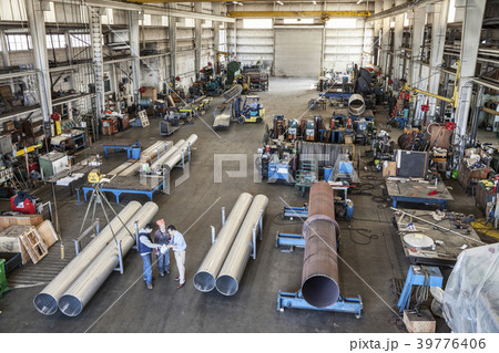 Mixed race team of workers and management people in a large sheet metal factory 39776406