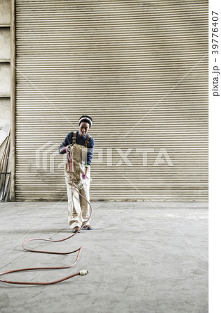 Black woman factory worker gathering tools together on the floor of a sheet metal factory. Black woman factory worker gathering tools together on the floor of a sheet metal factory. 39776407