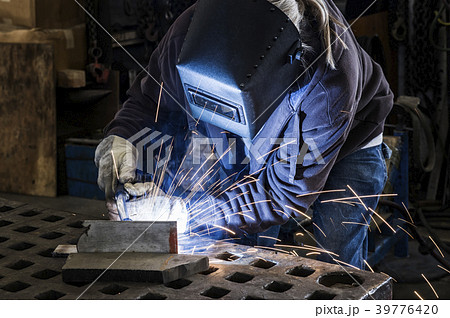 Factory worker using Oxyacetylene gas to weld two piece of metal in a sheet metal factory Factory worker using Oxyacetylene gas to weld two piece of metal in a sheet metal factory 39776420