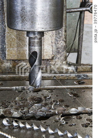 Closeup of a drill bit in a drill press in a sheet metal factory. 39776470