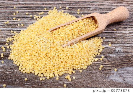 Heap of millet groats with spoon 39778878