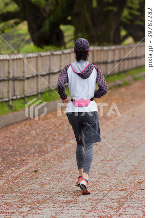 春の公園でランニングしている若い女性 39782282
