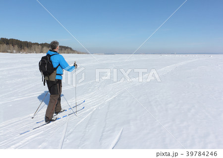 Man with a backpack is skiing on the frozen river 39784246