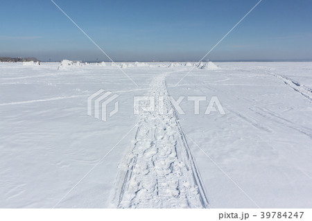 Trace of a snowmobile on a f frozen reservoir Trace of a snowmobile on a f frozen reservoir 39784247