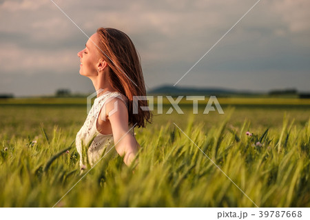 Beautiful woman in white dress on green wheat field Beautiful woman in white dress on green wheat field 39787668