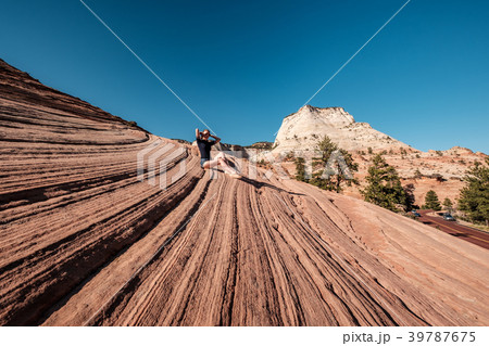 Woman sitting on rock formation in Utah, USA Woman sitting on rock formation in Utah, USA 39787675