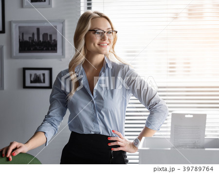 Cheerful business lady relaxing at her workplace Cheerful business lady relaxing at her workplace 39789764