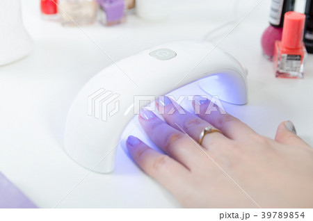 Woman using UV light dryer 39789854