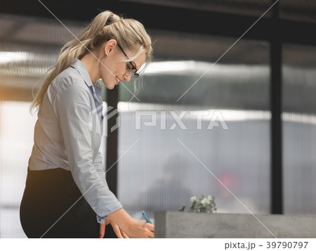 Cheerful businesswoman signing document with 39790797