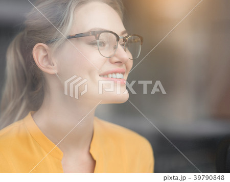 Joyful young woman viewing street from glass 39790848