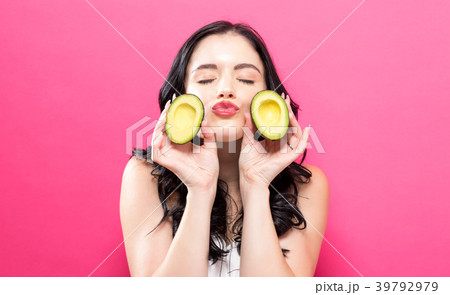 Young woman holding an avocado 39792979