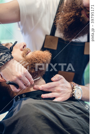 Close-up of the hand of a barber using scissors Close-up of the hand of a barber using scissors 39795171