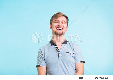Portrait of happy handsome man laughing on blue 39798381