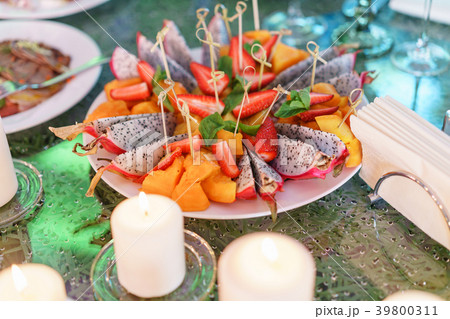 Plate with sliced fruits and berries on a servered Plate with sliced fruits and berries on a servered 39800311