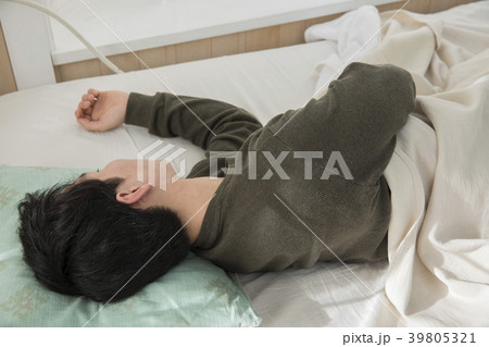 ベッドで眠る若い男性 39805321