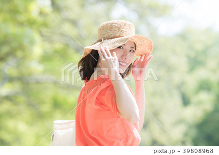 麦わら帽子をかぶる若い日本人女性の写真素材