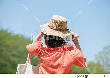 麦わら帽子をかぶった若い女性の後ろ姿の写真素材