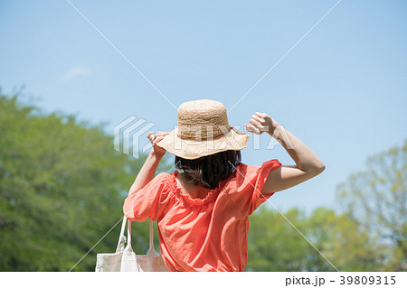 麦わら帽子をかぶった若い日本人女性の後ろ姿の写真素材