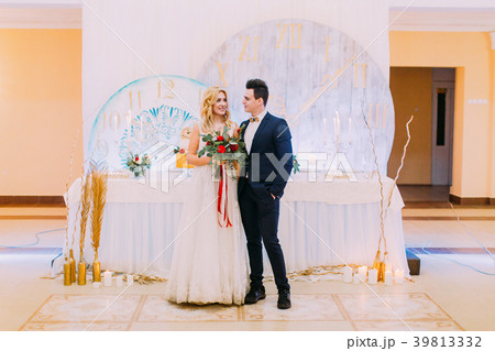 Happy young wedding couple posing with bouquet of Happy young wedding couple posing with bouquet of 39813332