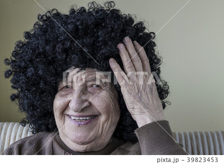 funny senior woman wearing curly black wig 39823453