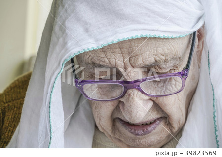 senior woman wearing headscarf while praying 39823569