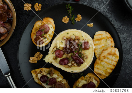 Brie cheese baked with nuts and grapes Brie cheese baked with nuts and grapes 39832798