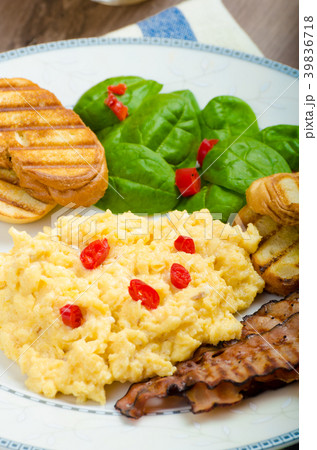 Scrambled eggs with toast and fresh salad 39836718