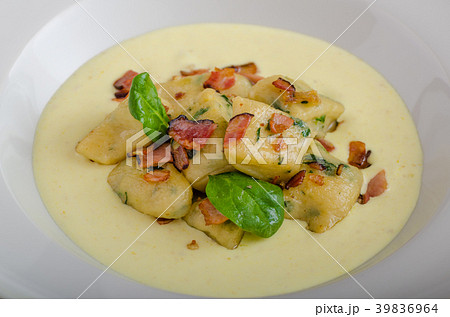 Spinach gnocchi with parmesan sauce topped with bacon 39836964