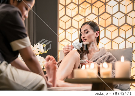 Therapist massaging the foot of a female client in Therapist massaging the foot of a female client in 39845471