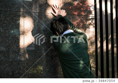 もたれて落ちこむ男性 39847054
