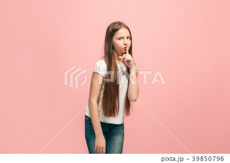 The young teen girl whispering a secret behind her The young teen girl whispering a secret behind her 39850796