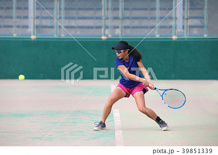 バックハンドを打つ女子ジュニアテニスプレイヤーの写真素材