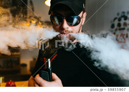 Brutal bearded man in sunglasses smoke an Brutal bearded man in sunglasses smoke an 39855907