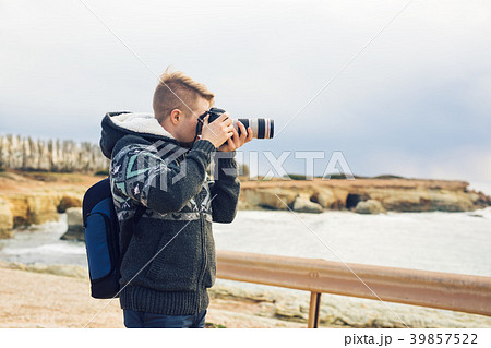 Young photographer with backpack making photos of 39857522