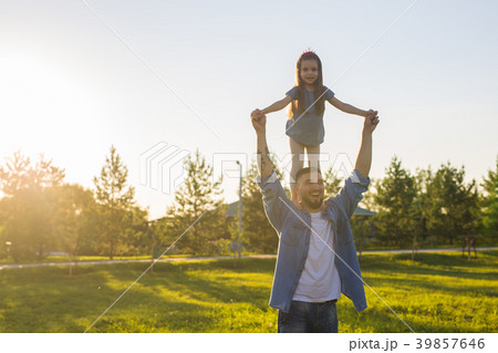 Happy man holding his little daughter on neck in 39857646