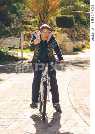 Handsome young man with bicycle showing thumbs up 39857855