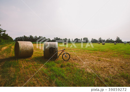 Bicycle in the field with big round bales of straw 39859272