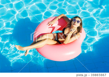 happy woman with inflatable ring relaxing in pool 39865667