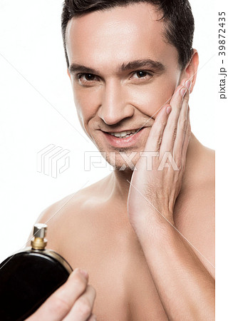 Handsome man using perfume isolated.  39872435
