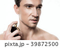 Handsome man using perfume isolated. Beauty man  39872500