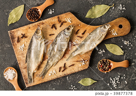 Dried fish with salt and pepper on cutting board 39877378
