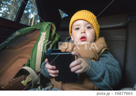 Little boy with gadget in car Little boy with gadget in car 39877663