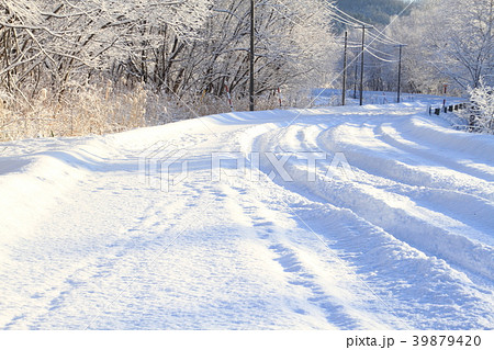 冬景色 北海道の雪道 新雪 里山の冬 朝の風景と続く一本道の写真素材