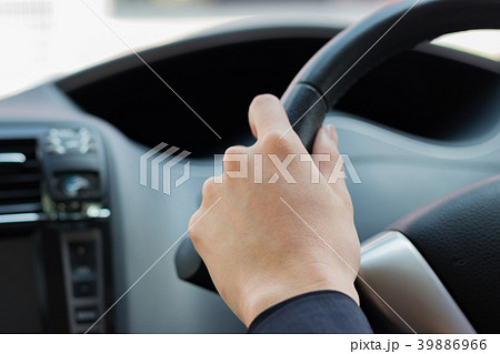 車のハンドルを握る手の写真素材