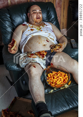 Fat man eating junk food and watching television Fat man eating junk food and watching television 39891722