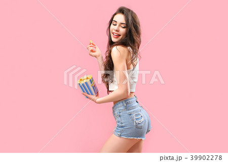 Playful girl with pack of popcorn Playful girl with pack of popcorn 39902278