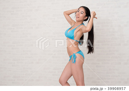 ビキニを着ている女性が、白い背景の前でいろいろなポーズや表情をしています。 ビキニを着ている女性が、白い背景の前でいろいろなポーズや表情をしています。 39908957