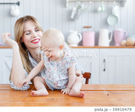 Young mother playing with her baby daughter in a 39910479