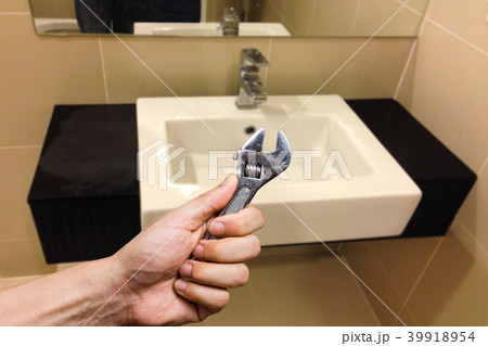 wrench in hand with faucet. home services concept wrench in hand with faucet. home services concept 39918954